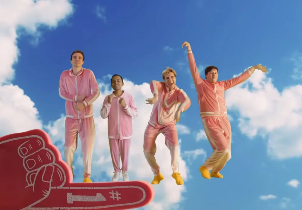 The boy band, Boy Throb, against a green screen cloud background with a foam number 1 hand in the right corner. The music video is called Finger.