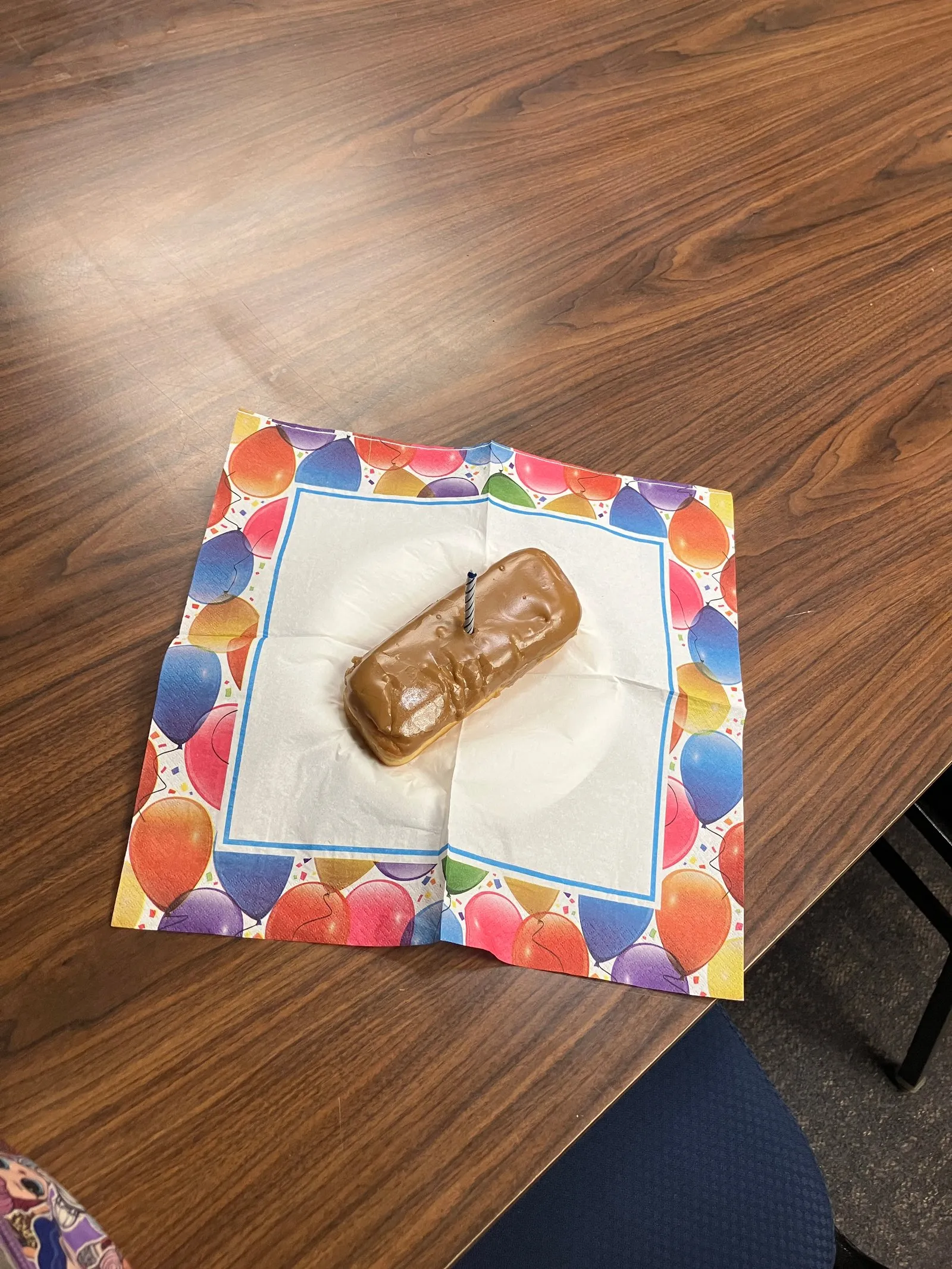 A maple bar with a candle - breakfast for champions turned celebration.