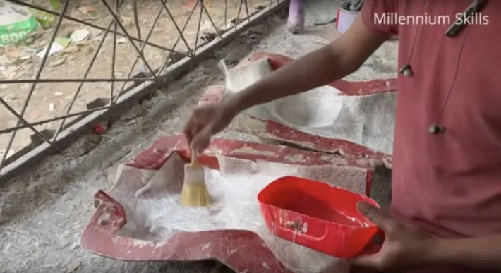 Adding glue to the fiberglass in a mold.